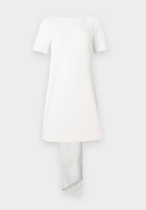 Robe blanche à manches courtes avec un col rond simple et un ourlet légèrement asymétrique, fabriquée dans un tissu lisse sans motifs visibles.