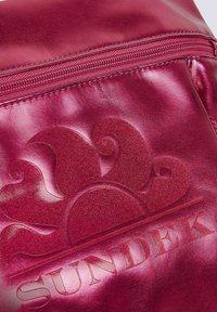 Borsa in pelle magenta con un design a onde testurizzate e stampa in rilievo del logo "SUNDEK". Presenta una chiusura con cerniera superiore. Superficie liscia e riflettente.