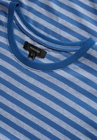 Mėlynas ir baltas dryžuotas medvilninis marškinėliai su apvaliu kaklu, ant juodo etiketės yra užrašas "Martinique" ir dydis "L".