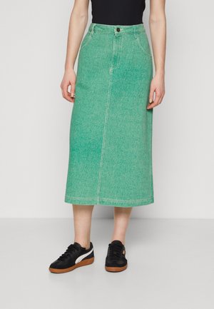 Green denim midi skirt with a straight cut, front seam detail, and single button closure, paired with black sneakers.