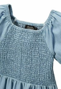 Robe bleu clair avec un corsage froncé, des manches courtes bouffantes et une taille cintrée. Le tissu est doux avec une finition légèrement texturée.