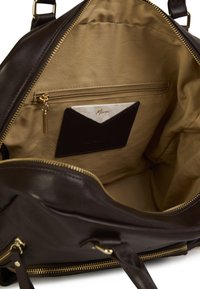 Borsa a mano in pelle marrone scuro con ferramenta dorata, dotata di un ampio interno foderato in tessuto chiaro, compreso un taschino con zip e portacarte.