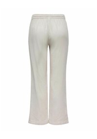 Pantalons larges crème en tissu texturé, avec une taille élastique et une silhouette décontractée, présentant des détails de couture minimaux.