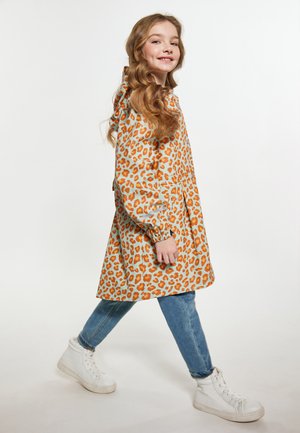 Læderjakke i leopardprint i lyseblå og orange, med hætte og elastiske manchetter, sat sammen med blå jeans og hvide sneakers.
