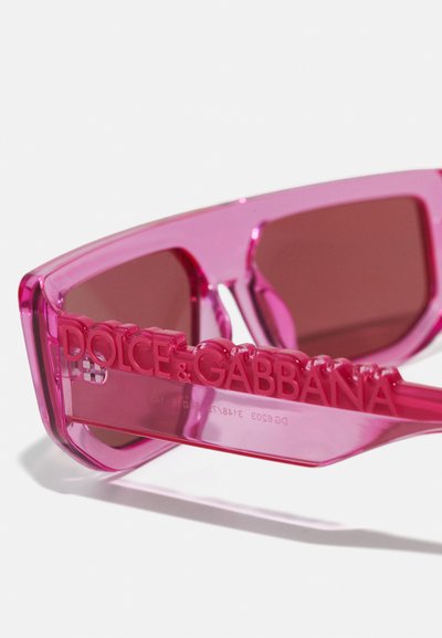 Rózsaszín, átlátszó napszemüveg, téglalap alakú, sötét, egyszínű lencsékkel és dombornyomott "Dolce & Gabbana" logóval a szárakon.