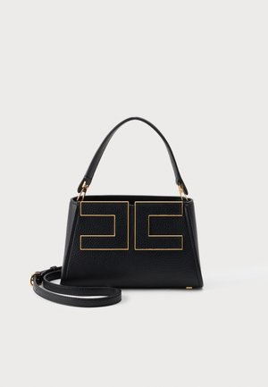 Sac à main en cuir noir avec poignée supérieure, accents géométriques dorés à l'avant et bandoulière détachable sur fond blanc.