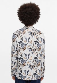 Shirt featuring a swirling pattern in blue, black, and brown on a white background, made of lightweight fabric with a collar and button cuffs.