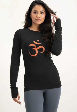 Langärmliges schwarzes Shirt mit einem orangefarbenen Om-Symbol in der Mitte. Hergestellt aus einem weichen Stoff, mit eng anliegenden Ärmeln und einem runden Ausschnitt.