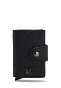 Cartera de cuero negro texturizado con cierre de correa a presión y logotipo plateado "HUGO" en el panel frontal inferior.
