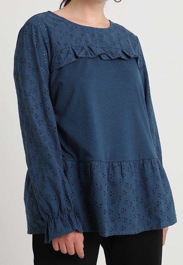 Blusa blu a maniche lunghe con pannello di pizzo arricciato, corpo testurizzato con motivi a occhiello e maniche arricciate.