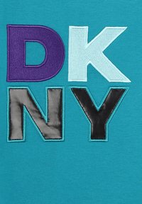 Tejido en color teal con las letras "D" (púrpura), "K" (azul claro), "N" (cuero negro) y "Y" (negro) en diversas texturas y colores.