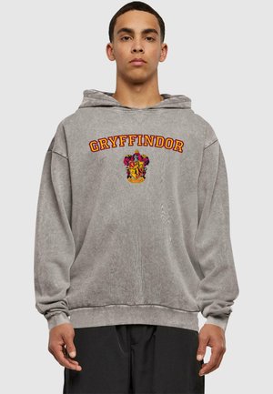 Gray hooded sweatshirt featuring "GRYFFINDOR" logo in orange above a colored crest. Soft texture, relaxed fit, and ribbed cuffs.