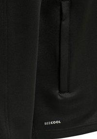 Schwarze Sportjacke aus glattem Material mit einer versteckten Tasche und einem kleinen weißen "BEECOOL"-Logo an der unteren rechten Seite.