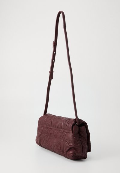 Burgundy leather crossbody bag with embossed floral patterns, a flat design, and an adjustable strap for customization.