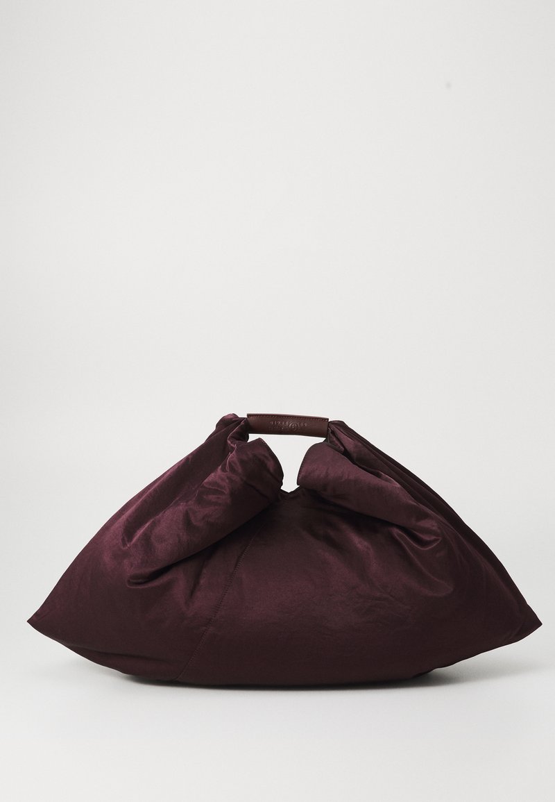 Large soft burgundy handbag with a gathered top and short handle wrapped in matching leather on a plain background.