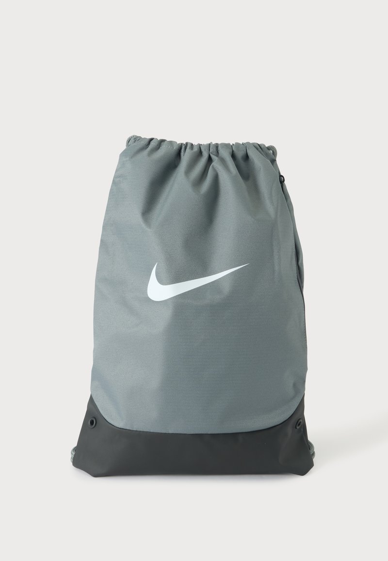Γκρι και μαύρο σακίδιο πλάτης Nike με κορδόνι, με λευκό λογότυπο swoosh στο κέντρο μπροστά και εσωτερικό κλείσιμο στην κορυφή.