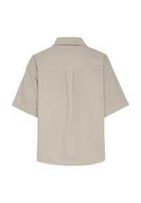 Short-sleeve shirt in light beige fabric, featuring a classic collar, back pleat detail, and a straight hem. Smooth texture.