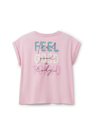 T-shirt rosa a maniche corte con design grafico del testo che recita "FEEL GOOD in TOKYO" in vari colori e font. Tessuto morbido.