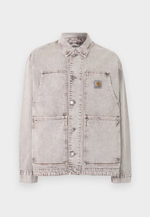 Veste de travail en denim gris clair avec fermeture à boutons, deux grandes poches basses, deux poches poitrine et un petit patch logo carré sur la poitrine gauche.