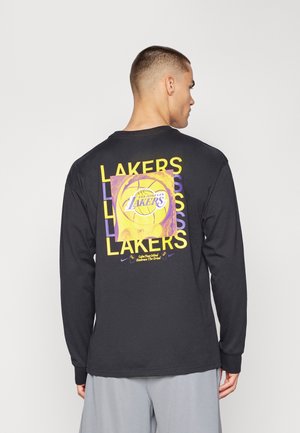 Melnas garām piedurknēm t-krekls ar dzīvīgu dzeltenu un purpura grafiku ar basketbola bumbu un "Lakers" tekstu mugurpusē. Mīksts kokvilnas materiāls.