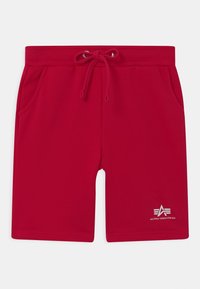 Czerwone bawełniane szorty z sznurkiem w talii, bocznymi kieszeniami i małym białym logo na lewym dolnym udzie. Gładka tekstura, casualowy design.