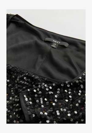 Robe noire à paillettes avec un col en satin. Présente des paillettes rondes dans des teintes variées réfléchissant la lumière. Étiquette de marque visible.