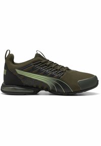 Zapatilla deportiva de malla verde con acentos negros, parte superior texturizada, cordones finos y una almohadilla de aire visible en la suela para mayor soporte.