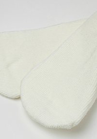 Calze alla caviglia in cotone di colore bianco sporco, con texture a coste, punta arrotondata e bordo liscio. Design leggero e traspirante.