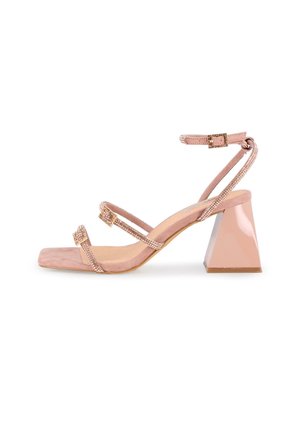 Sandal de ante rosa con tacón de bloque y tres tiras brillantes, y punta cuadrada. Presenta un tacón brillante con forma geométrica y hebilla en el tobillo.