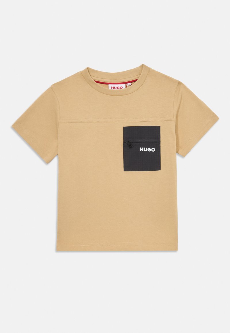 Bežové bavlněné tričko s krátkým rukávem, s černou kapsou na levé části hrudi a bílým logem.