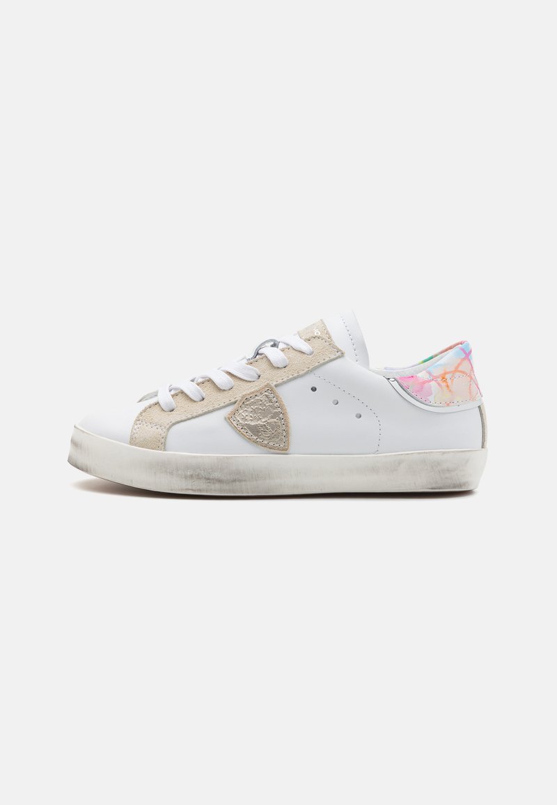 White sneaker with beige suede accents, rounded toe, and textured heel featuring a colorful, pastel design. Lace closure and rubber sole.
