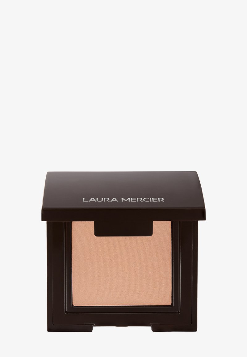 Geperst poeder compact van Laura Mercier met een matte zwarte buitenkant en zachte beige poeder aan de binnenkant, met een transparante deksel en logo.