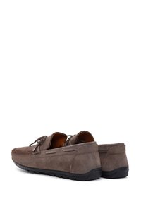 Zapatos mocasines de ante marrón con un acabado texturizado, diseño con cordones, perfil bajo y suelas de goma para mayor flexibilidad y agarre.