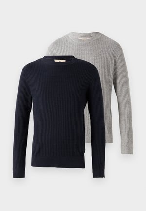 Kaks sviitrit: üks tume sinine ja ribakujuline, teine heledat halli värvi sarnase tekstuuriga disainiga. Mõlemal on ümmargune kaelus ja pikad varrukad.