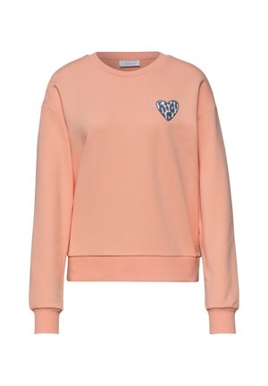 Licht perzikkleurige crewneck trui met lange mouwen en een klein donkerblauw hartje met luipaardprint op de linkerborst.