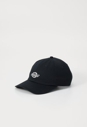 Sort baseballkasket med hvid Dickies-logo broderet foran, vist på en ensfarvet hvid baggrund.