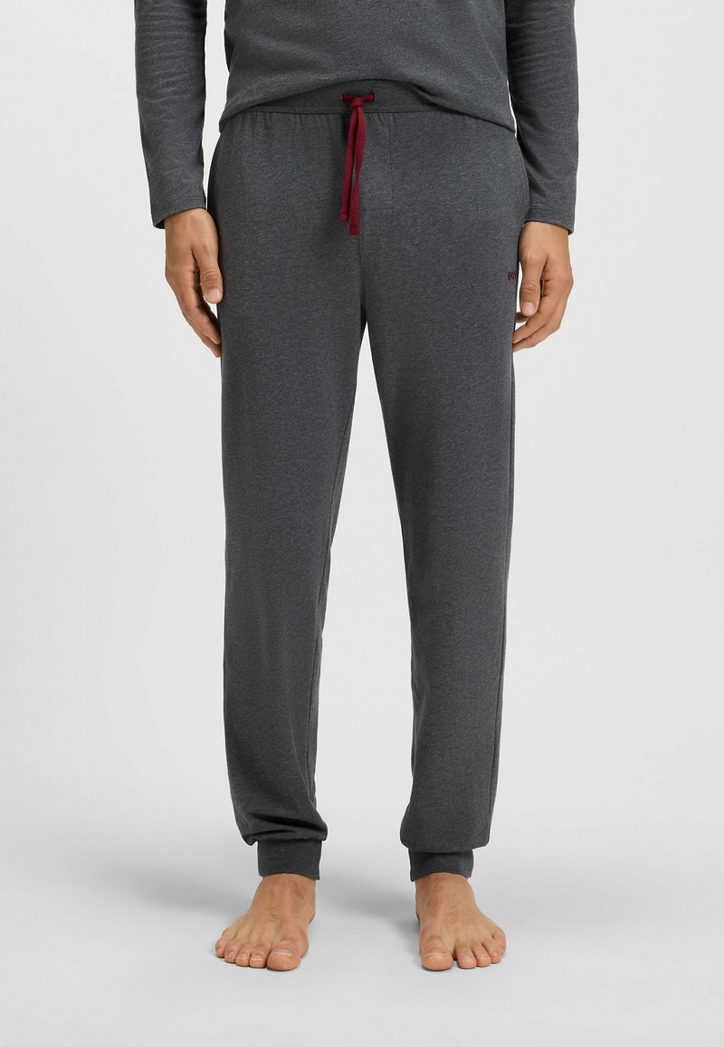Grå pyjamasbyxor i mjukt material, med elastisk midja och röd dragsko samt avsmalnande muddar.