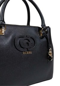 Borsa in pelle nera a grana con accessori in oro, logo impresso, doppio manico superiore e un accento di portachiavi. Superficie texturizzata per una presa migliore.
