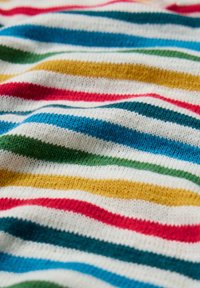 Tissu rayé multicolore avec des lignes horizontales blanches, rouges, bleues, vertes et jaunes. Texture douce avec un motif tricoté.