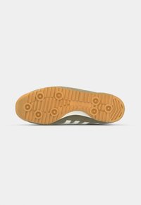 Olive green sneaker with a textured suede upper, white accent stripes, and a gum rubber outsole featuring circular tread patterns.