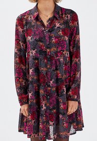 Robe à manches longues avec boutons en tissu sombre, ornée d'un motif floral dans des tons de rouge, rose et orange, avec une jupe à volants et une coupe décontractée.