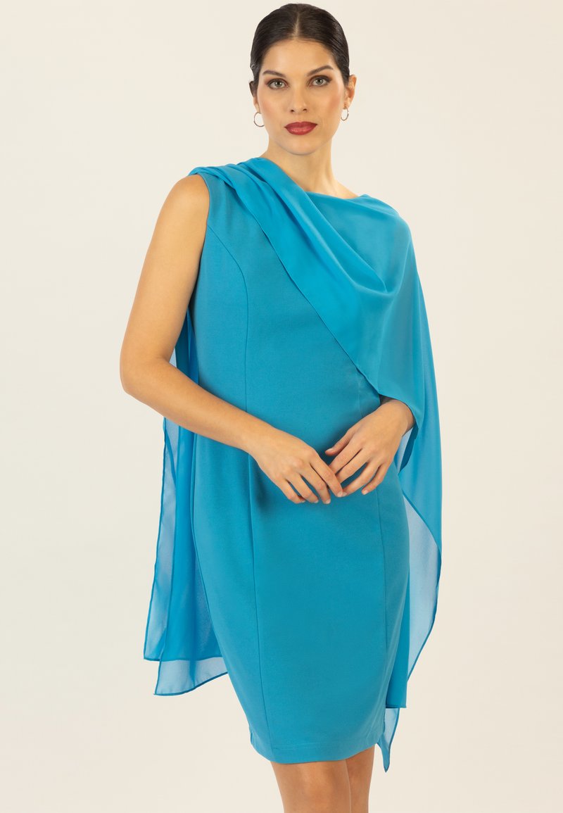 Ein blaues Kleid aus glattem Stoff mit einem fließenden, drapierten Überwurf an einer Schulter. Enganliegende Silhouette mit einem knielangen Saum.