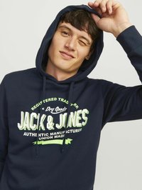 Sudadera azul marino hecha de una tela suave, con un gráfico frontal en verde brillante, capucha con cordón y puños acanalados.