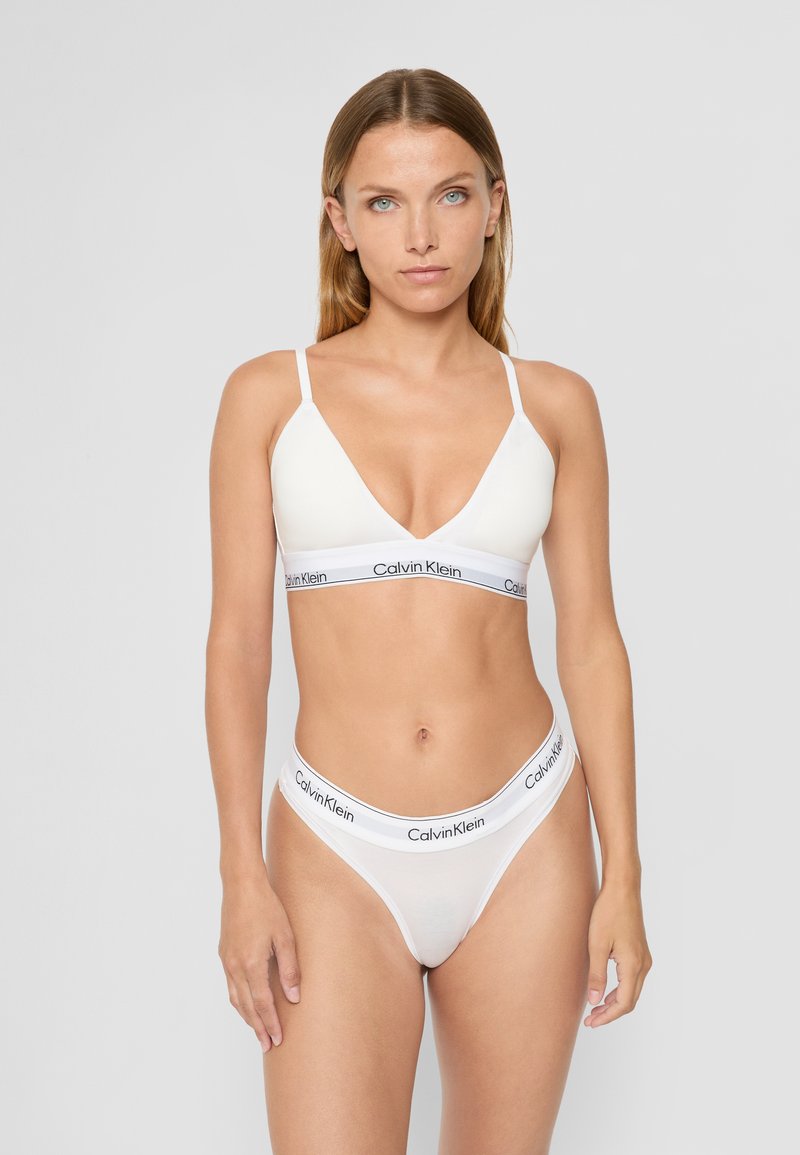 Hvit bomulls bralette og truse sett med justerbare stropper og en merket elastisk midjebånd. Glatt tekstur og minimalistisk design.