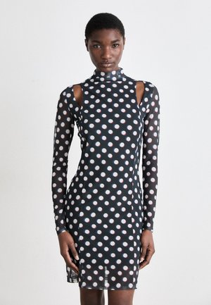 Black long-sleeve dress featuring a high neck, cut-out shoulders, and a polka dot pattern in white and red, fitted silhouette, smooth fabric.