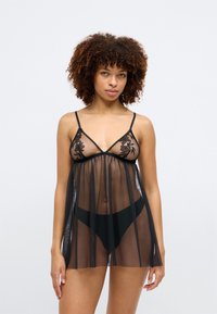 Svart gjennomsiktig babydoll-lingeri med blomstermønster, justerbare stropper og en luftig silhuett som faller over et matchende svart truse.