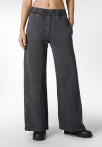 Brede broekspijpen in donkergrijze denim, met een elastische tailleband, zijzakken en een gladde textuur, voorzien van subtiele stikseldetails.