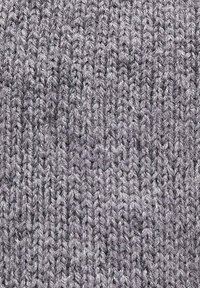 Tela de punto gris claro con un patrón texturizado y acanalado, con puntos consistentes y uniformes en toda su extensión. Textura suave, adecuada para prendas.