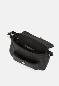 Borsa a tracolla in pelle nera aperta per mostrare il comparto principale con tasca con zipper e tasca frontale con chiusura magnetica.