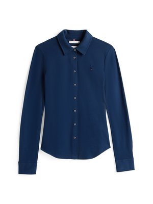 Camisa de botones de manga larga en color navy con cuello, hecha de una tela suave, que presenta un pequeño logo en el pecho y puños estándar.